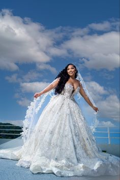 a woman in a wedding dress is posing for the camera with her arms spread out