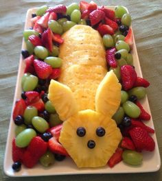 a white plate topped with fruit and an animal shaped in the shape of a face