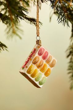 a christmas ornament hanging from a tree with macaroni and cheese on it