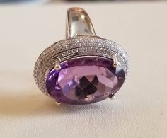 A big oval cut amethyst and diamond ring.nice color and good color 164 diamonds total weight 0.60 carat One oval amethyst ,size 16 x 13 mm, weight 10.20carat, 18 K white gold ring mounting 7.50 gram. Amethyst And Diamond Ring, Ring Mountings, Pretty Pendant, Diamond Settings, White Gold Ring, Amethyst Ring, Pearl Ring, White Gold Rings, White Gold Diamonds