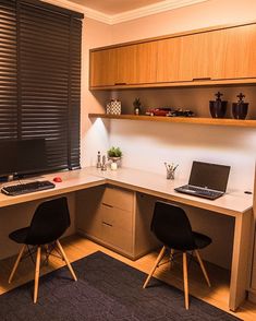 a desk with two chairs and a laptop on it