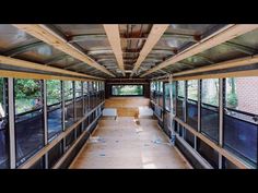 the inside of a bus with lots of windows and wood flooring on both sides