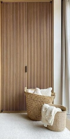 a room that has some baskets on the floor and a door in the wall behind it