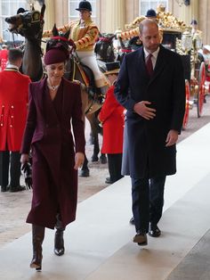 the queen and prince are walking in front of horse guards