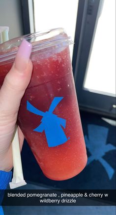 a person holding a drink in their hand with the words blended pomegranate, pineapple & cherry w