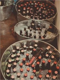 three metal buckets filled with bottles of beer