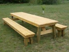 a wooden picnic table and benches in the grass