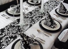 the table is set with black and white place settings