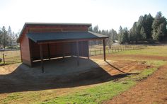 a horse barn in the middle of a field