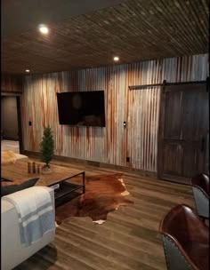 a living room with couches, chairs and a flat screen tv on the wall