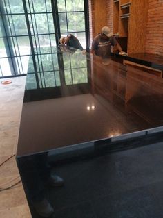 two people are standing at the counter in an empty room