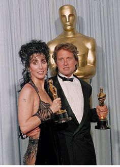 a man and woman posing with their oscars