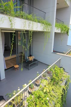 an apartment building with plants growing on the balconies