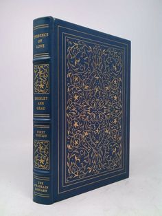 a blue book sitting on top of a white table next to a black and gold cover