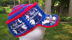 two blue and red crocheted hats on top of a white mannequin head