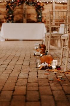 an outdoor ceremony with candles and pumpkins on the ground