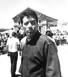 an old black and white photo of a man standing in front of a group of people