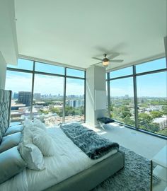 a bedroom with large windows overlooking the city