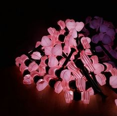 a pile of pink and black heart shaped candy lollipops sitting on top of a wooden table