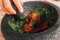 a person mixing food in a black bowl