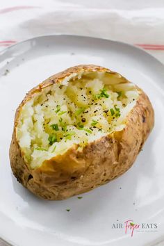 a baked potato is sitting on a white plate