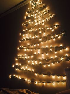 a lighted christmas tree in the corner of a room with lights on it's sides