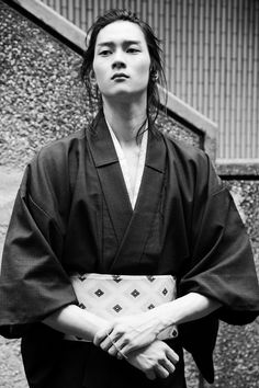 a woman standing in front of a building wearing a kimono