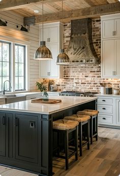 a large kitchen with an island in the middle and two pendant lights hanging from the ceiling