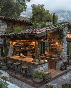 an outdoor bar with lots of seating and tables in front of the mountain side house