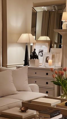 a living room filled with lots of furniture and flowers on top of a coffee table