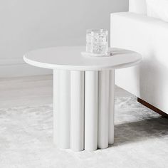 a white table sitting on top of a rug next to a couch