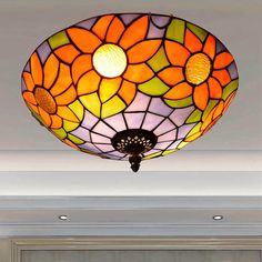 a ceiling light with a flower design hanging from it's center fixture in a living room