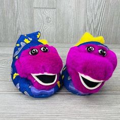 two purple and blue stuffed animals sitting next to each other