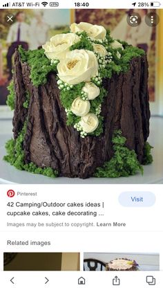 the cake is decorated with white flowers and greenery on it's side, along with an instagram page