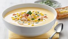 a white bowl filled with soup and garnished with corn