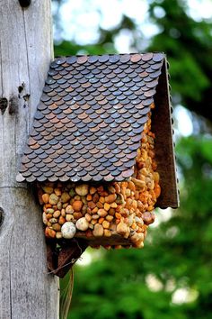 a birdhouse with a roof made of pennies