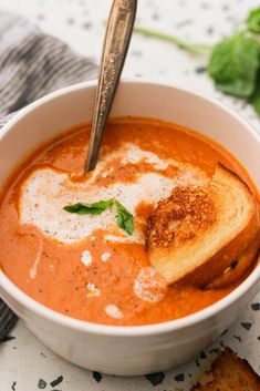 a bowl of creamy dairy - free roasted tomato soup with toasted bread on the side