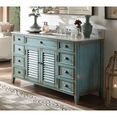 a bathroom with a blue vanity and mirror