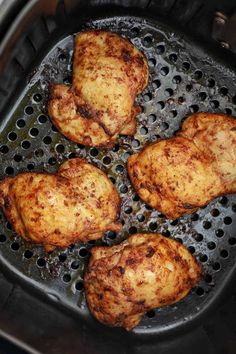 four pieces of chicken cooking in an air fryer