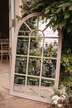 an arched window is decorated with greenery and seating for the guests to sit in