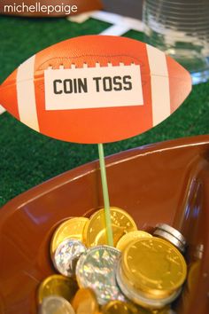 a football pinata sitting on top of a bowl filled with coins and gold coins