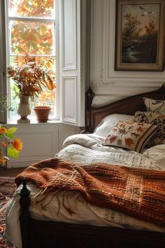 a bed in a bedroom with an orange blanket on it