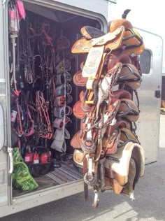 a horse trailer filled with lots of different types of saddles and bridles