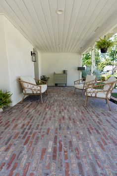 two chairs sitting on top of a brick covered patio