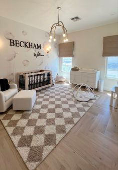 a baby's room with a checkered rug on the floor and white furniture