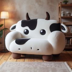 a cow couch sitting on top of a hard wood floor next to a lamp and bookcase