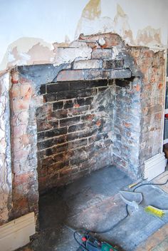 an old brick fireplace is being worked on