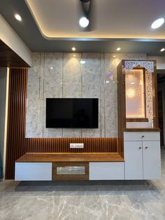 an entertainment center with a flat screen tv mounted on the wall and cabinets below it