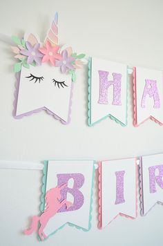 unicorn themed birthday banner hanging on the wall