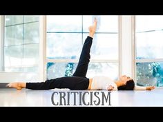 a woman laying on the floor in front of a window with her arms up and legs crossed